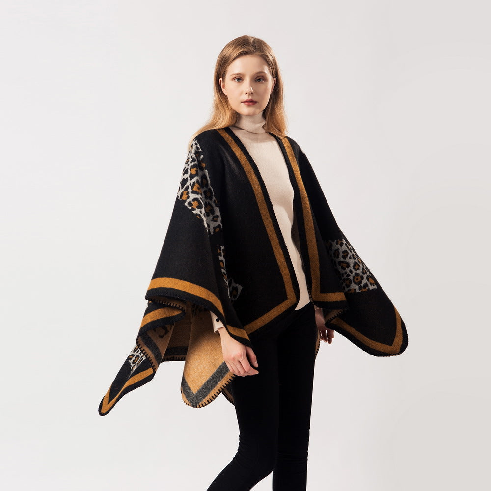 Black leopard-print cashmere shawl with tan border trim, worn draped over shoulders