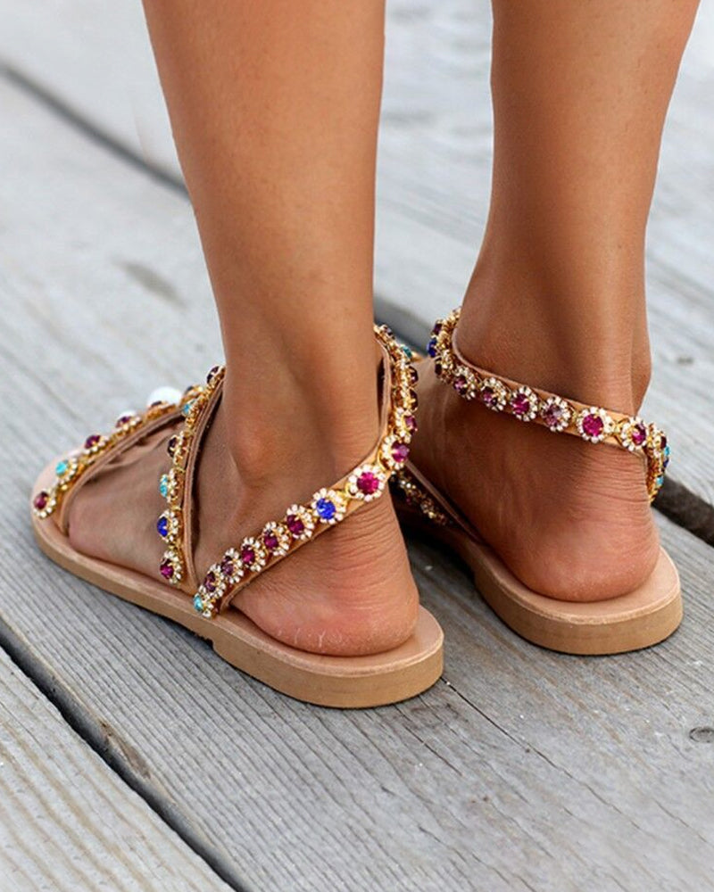 Gold-tone flat sandals with multicolor jeweled toe ring and ankle strap