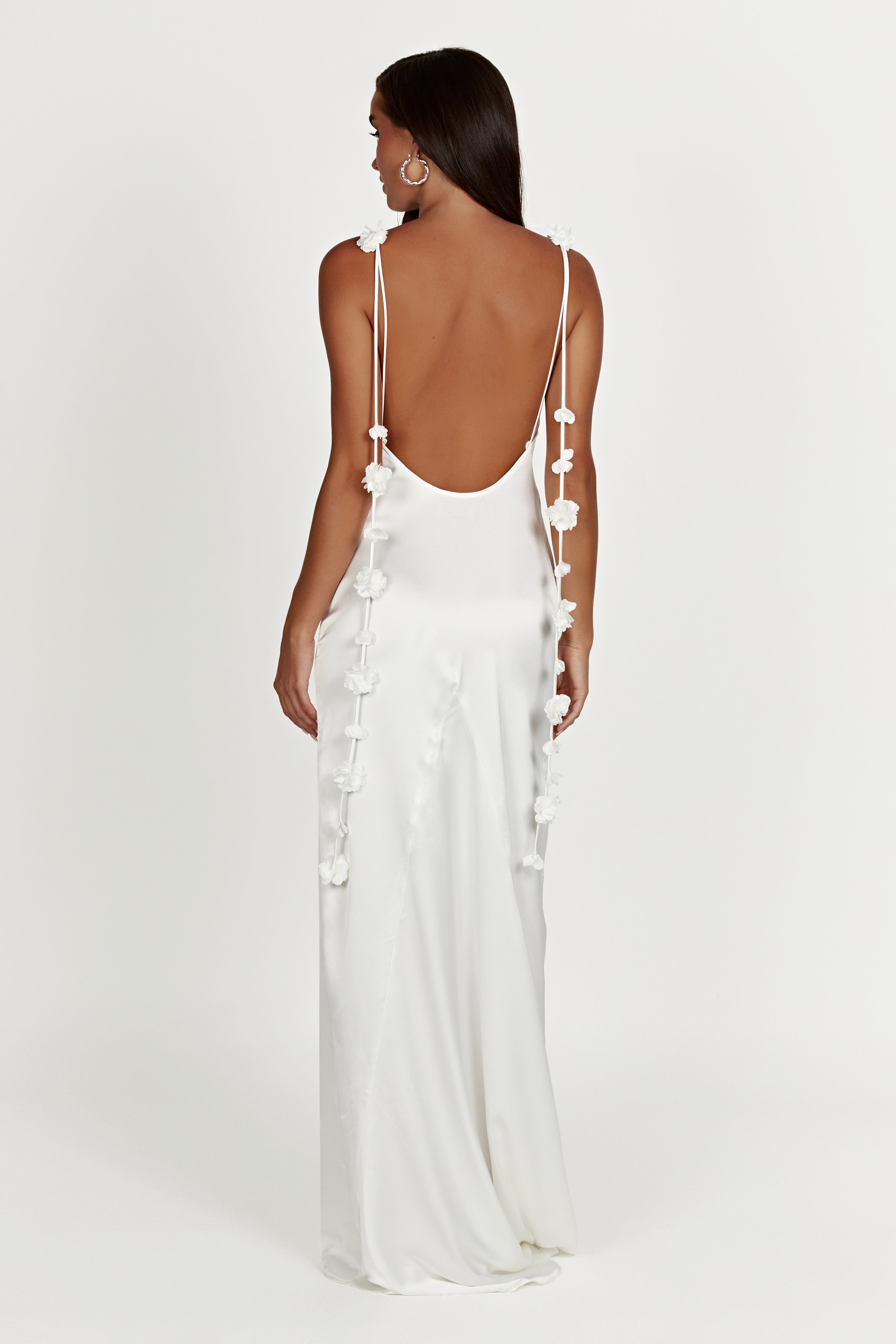 White backless satin slip maxi dress with thin straps and 3D floral embellishments