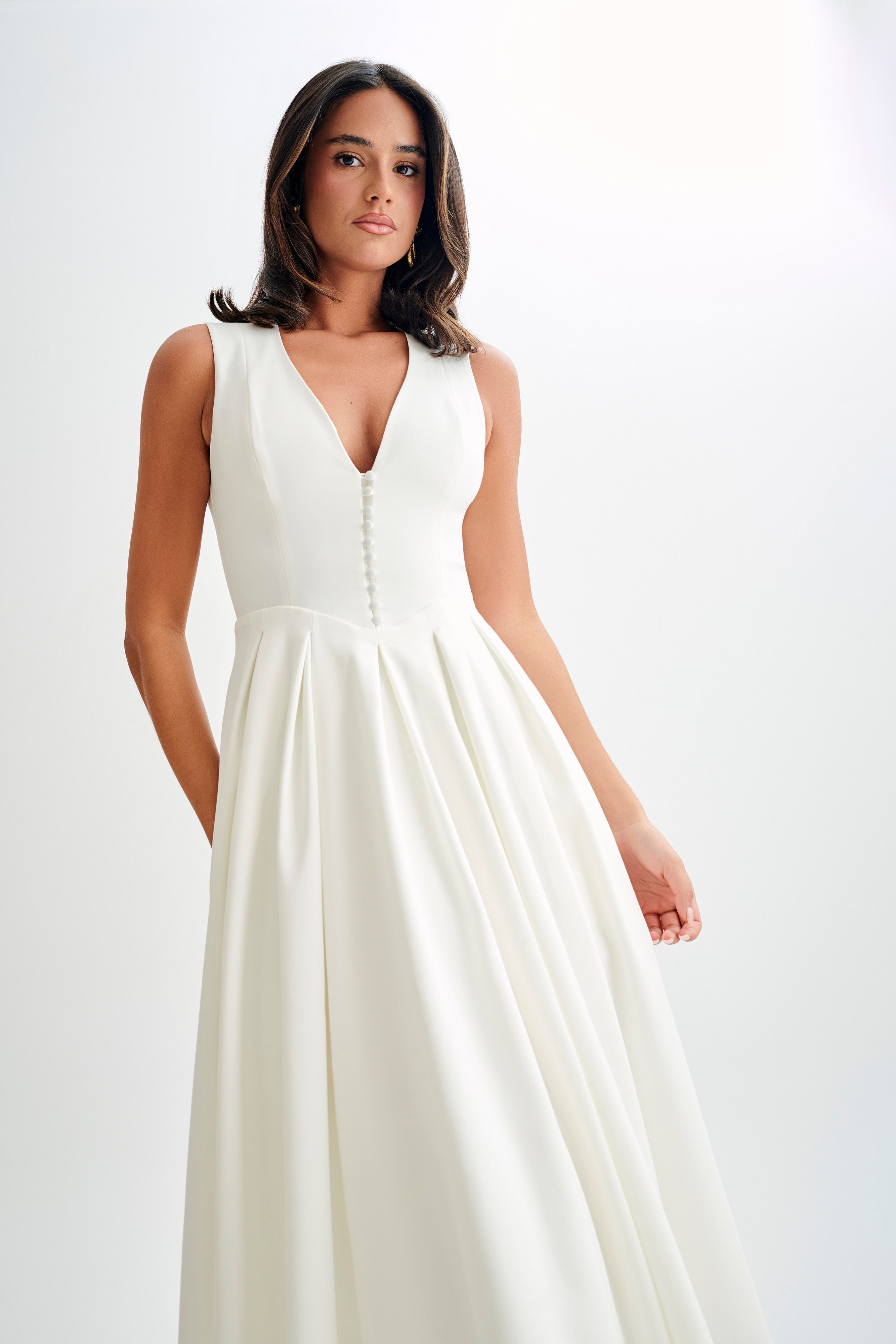 White satin sleeveless deep V midi dress with vertical button detail and gathered skirt