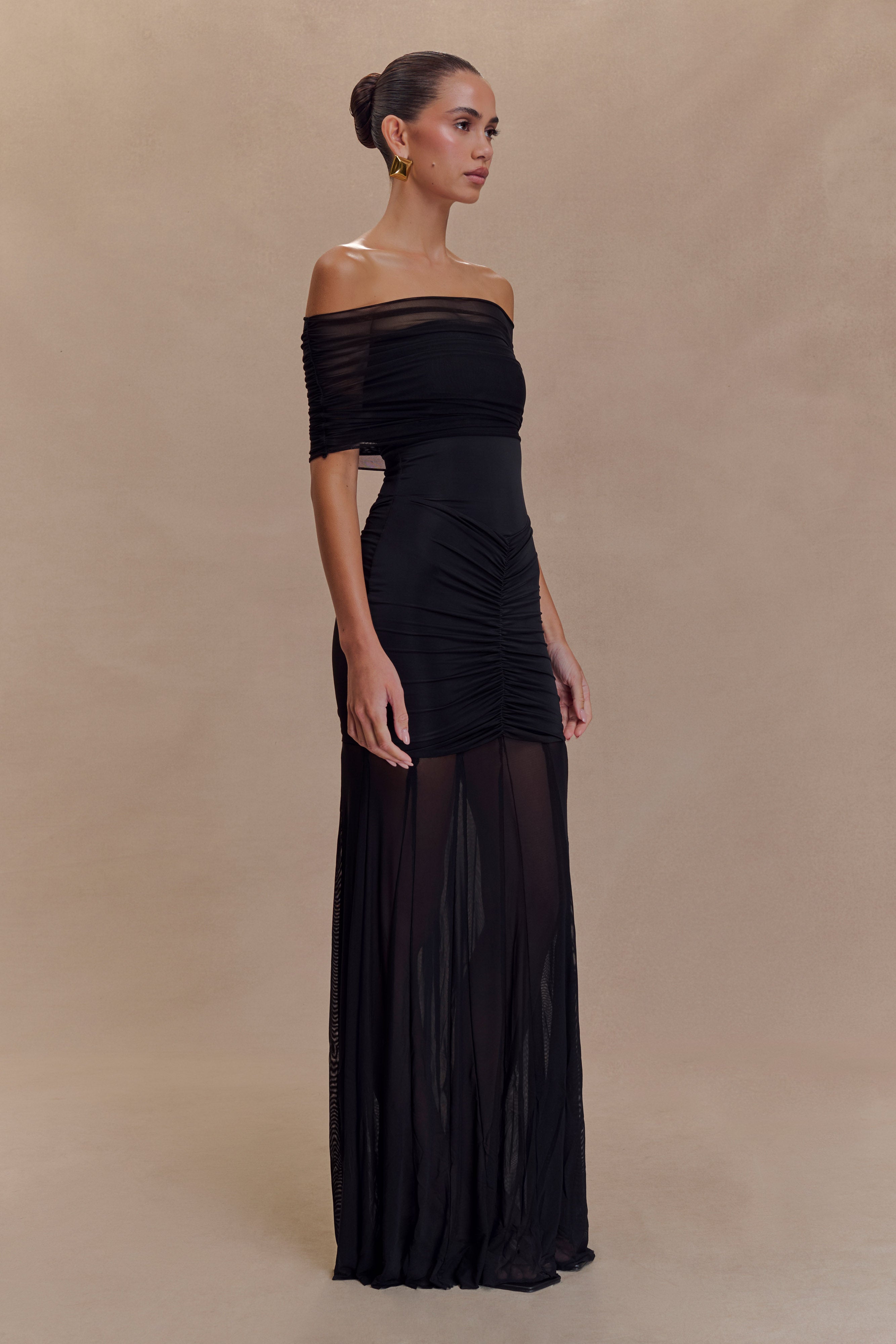 Black off-shoulder ruched bodycon maxi dress with sheer mesh skirt panel, side view