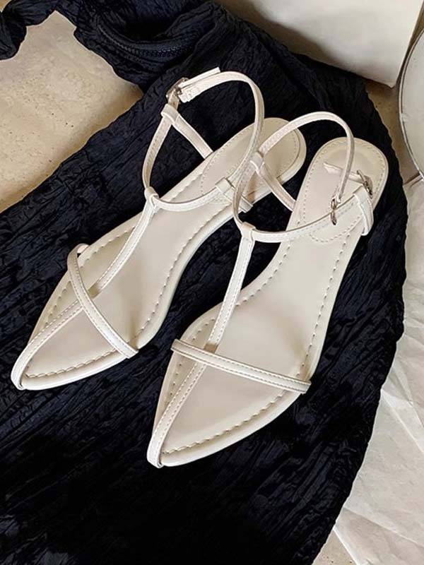 White faux leather T-strap flat sandals with pointed toe and adjustable ankle strap