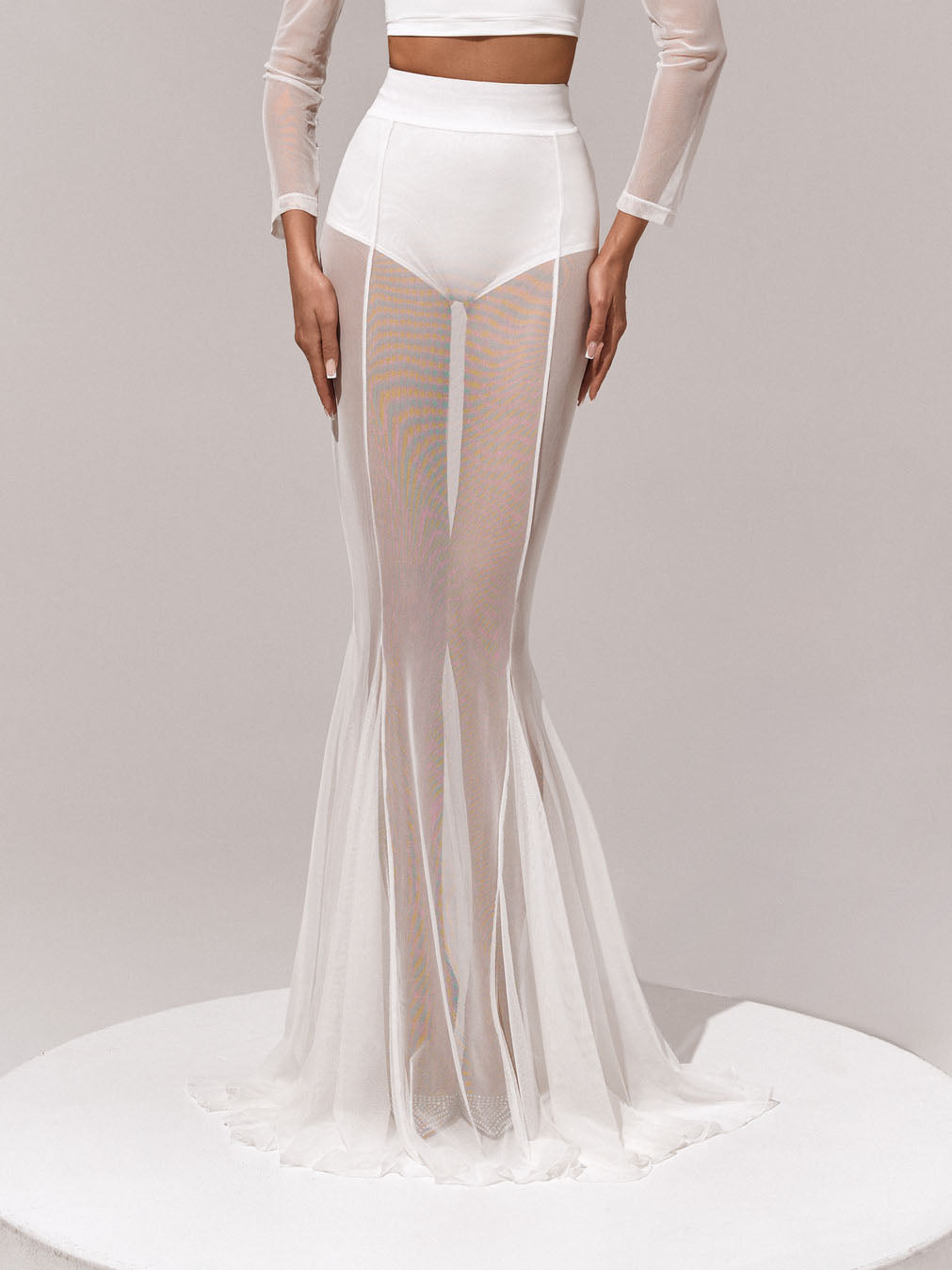 White sheer mesh flare-leg trousers with high waist and ruffled hem