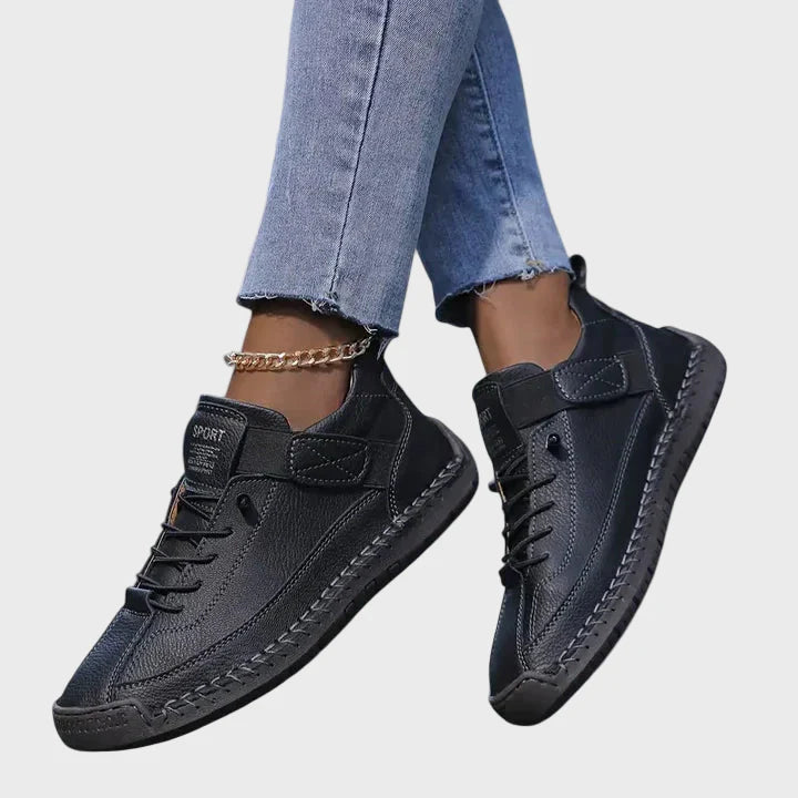 Black faux leather lace-up sneakers with ankle strap and beige-toned rubber sole