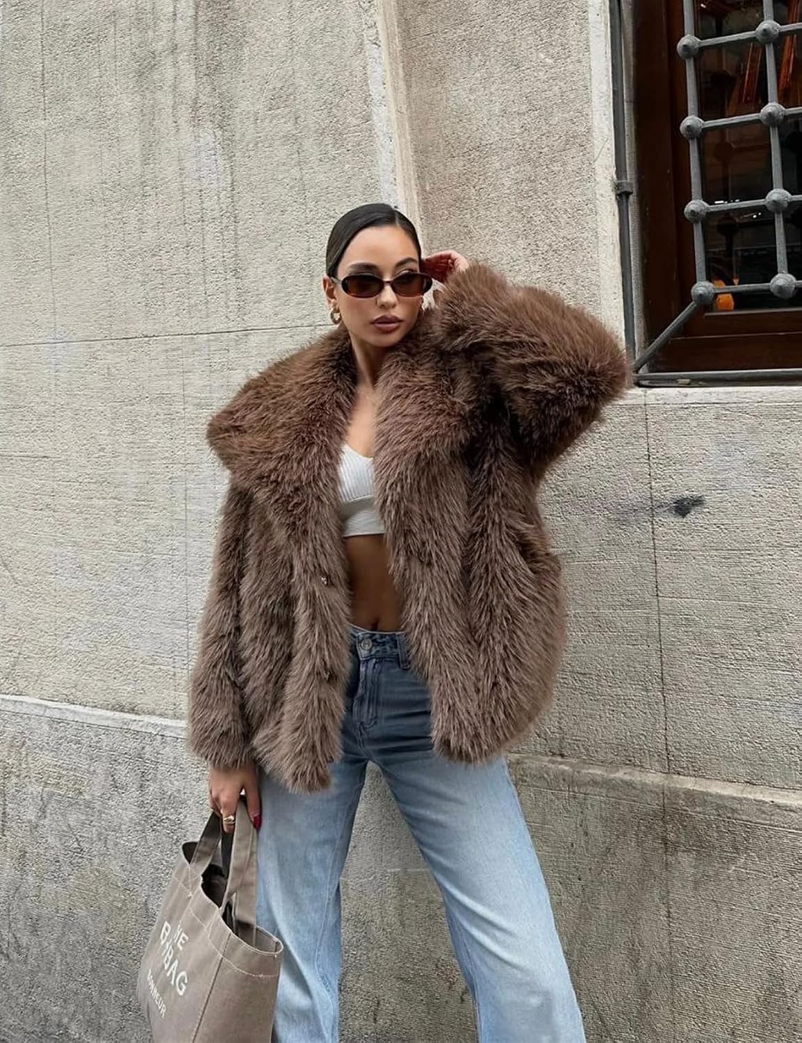 Oversized brown faux fur jacket with a wide collar, worn open