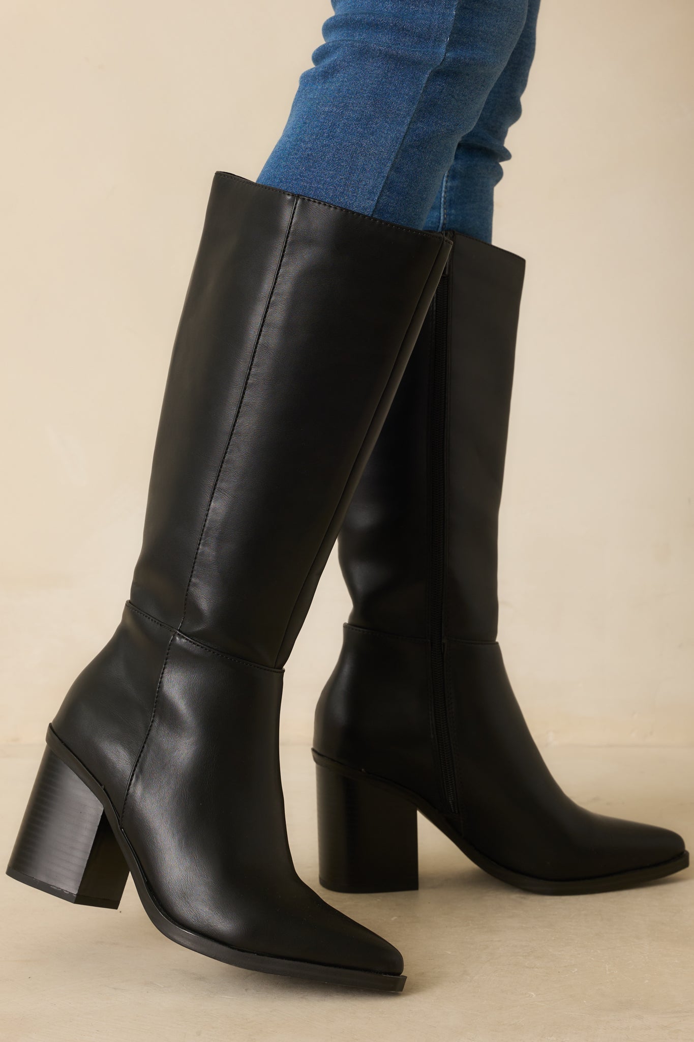 Black knee-high faux leather boots with block heel and pointed toe