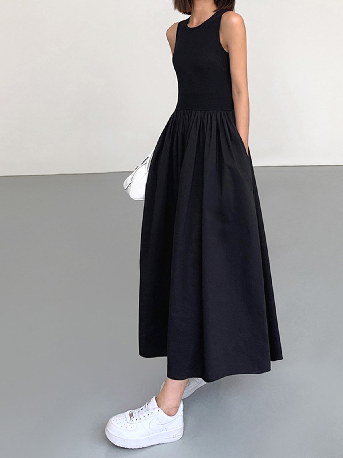 Black cotton sleeveless midi dress with ribbed bodice and gathered skirt, side view