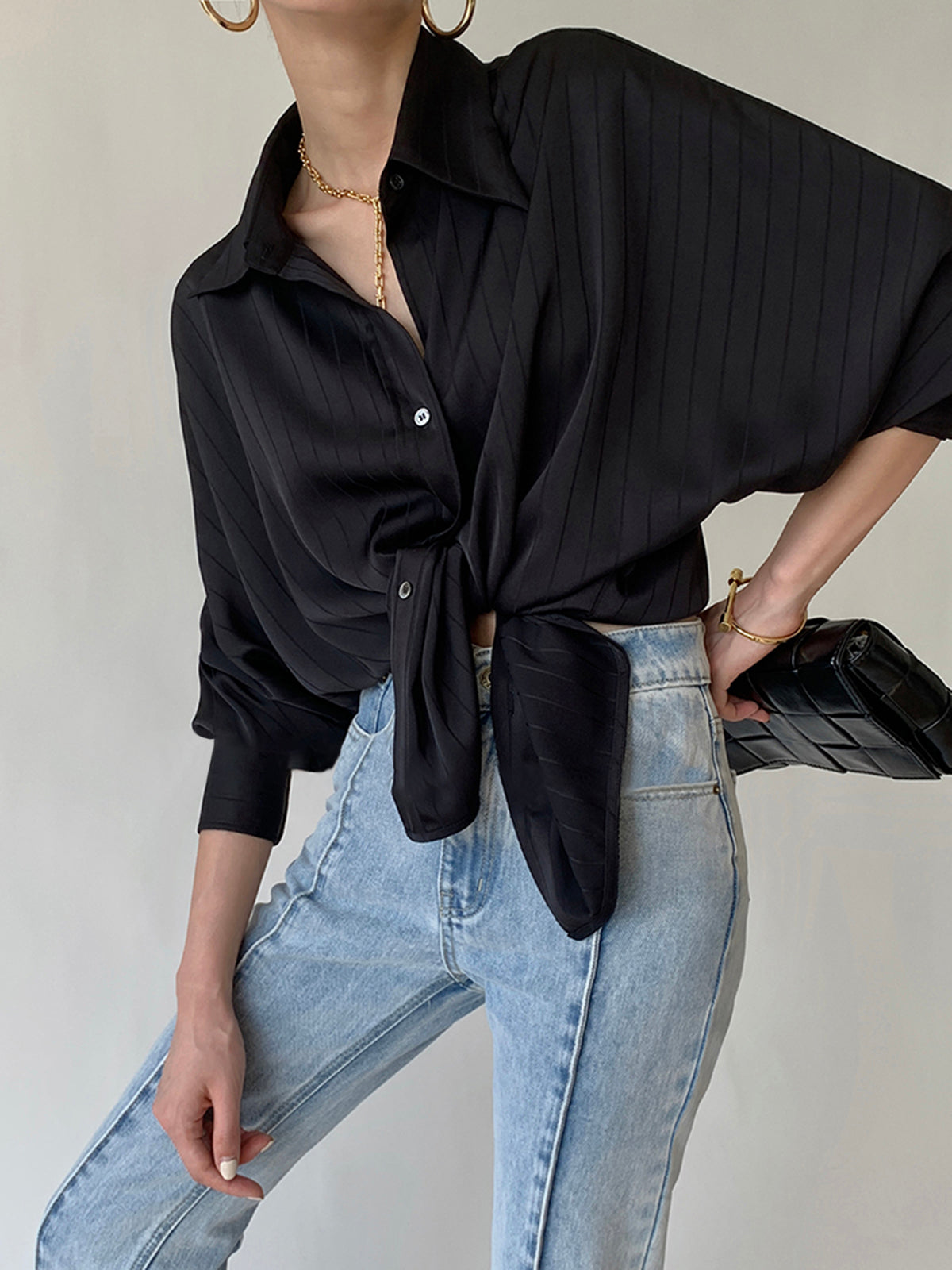 Black satin oversized button-front blouse with long sleeves, tied waist, tonal stripe
