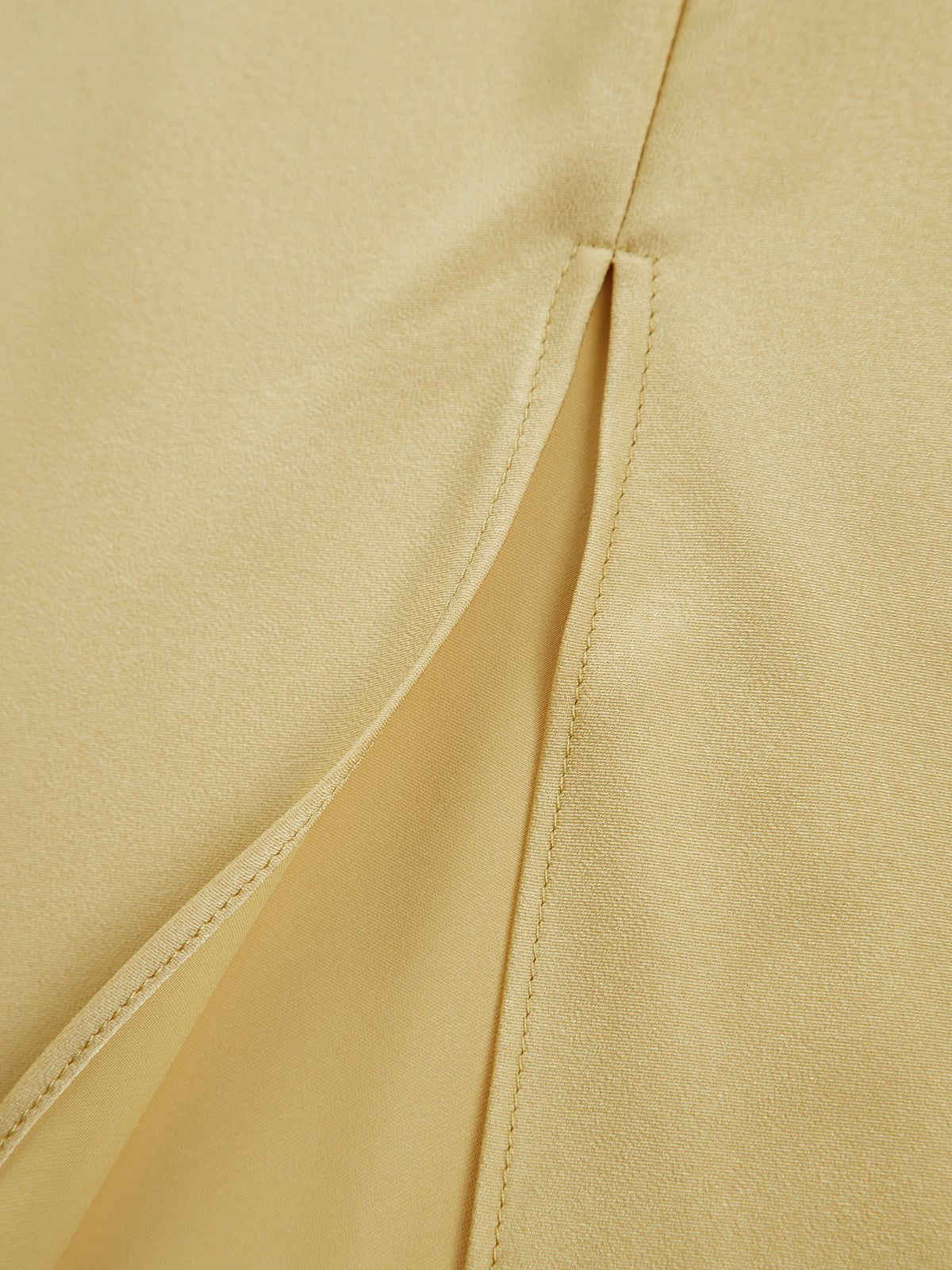 Yellow satin close-up showing stitched seam and side split