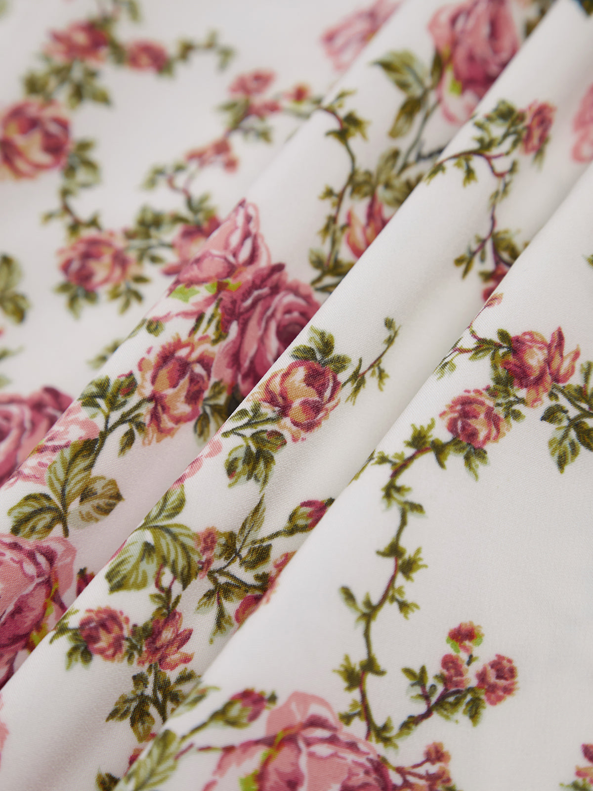 Pink floral cotton fabric closeup with rose print and soft drape