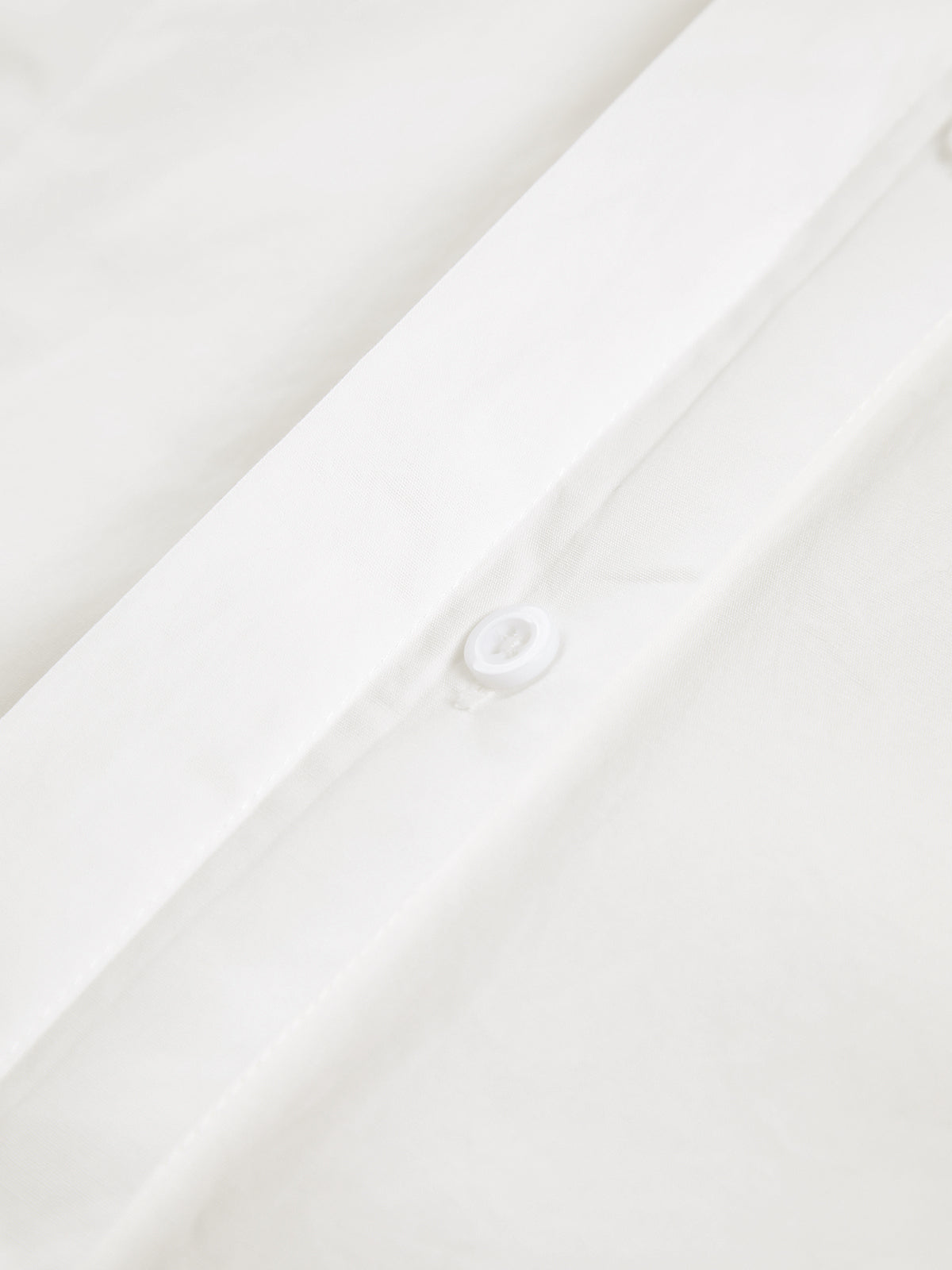Close-up of white cotton blouse button placket