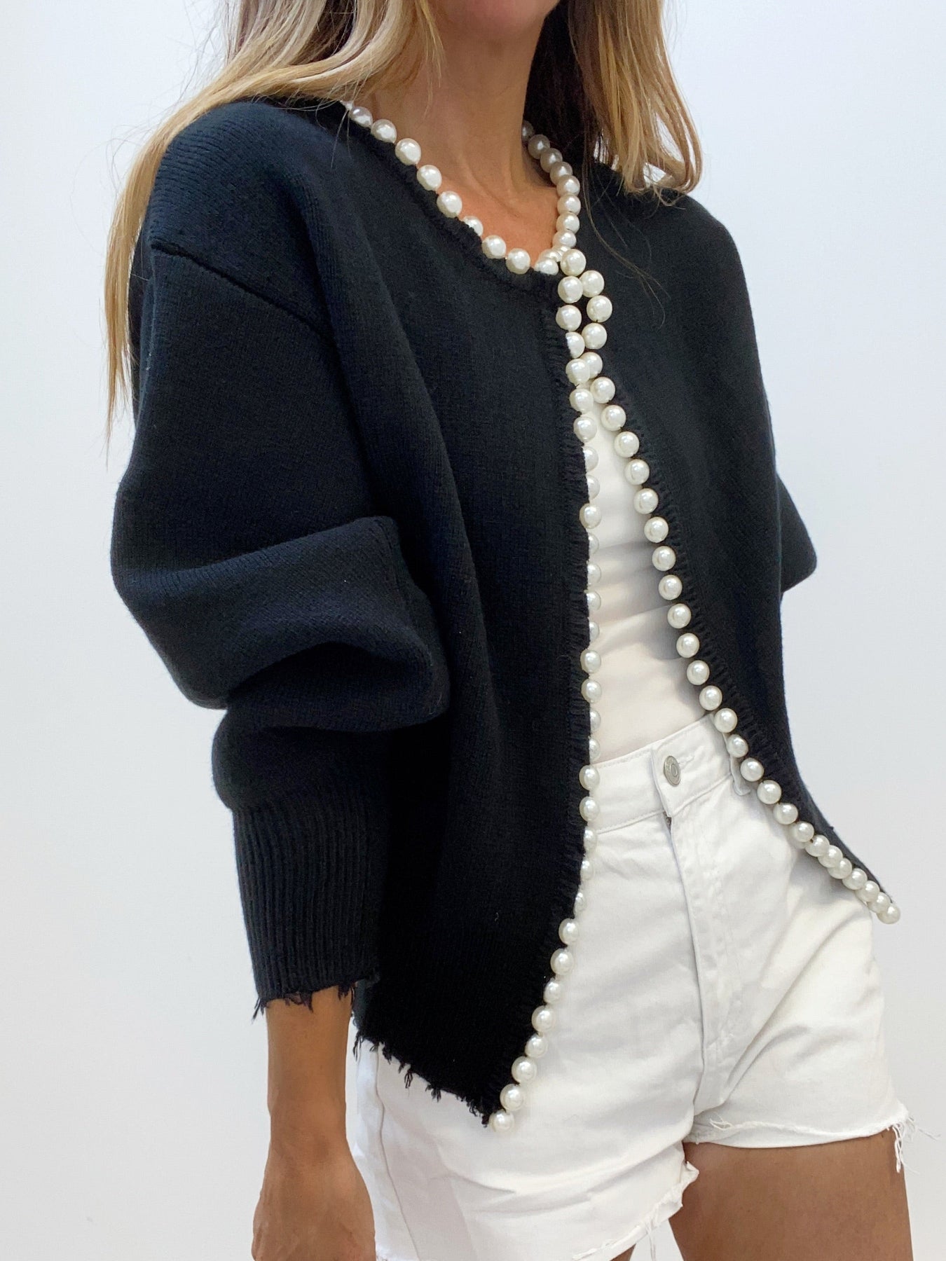 Women's black open-front knit cardigan with cascading pearl trim and puff sleeves