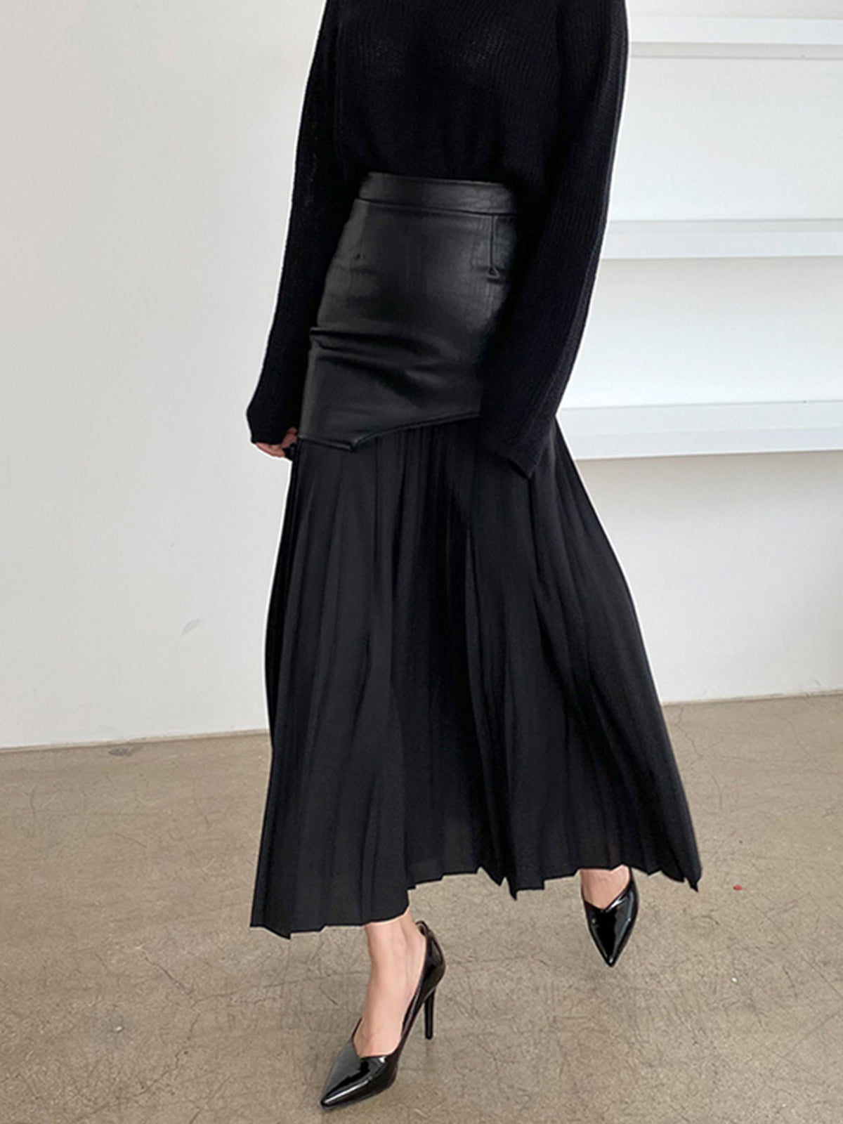 Black leather maxi skirt with pleated panels and asymmetric waist overlay