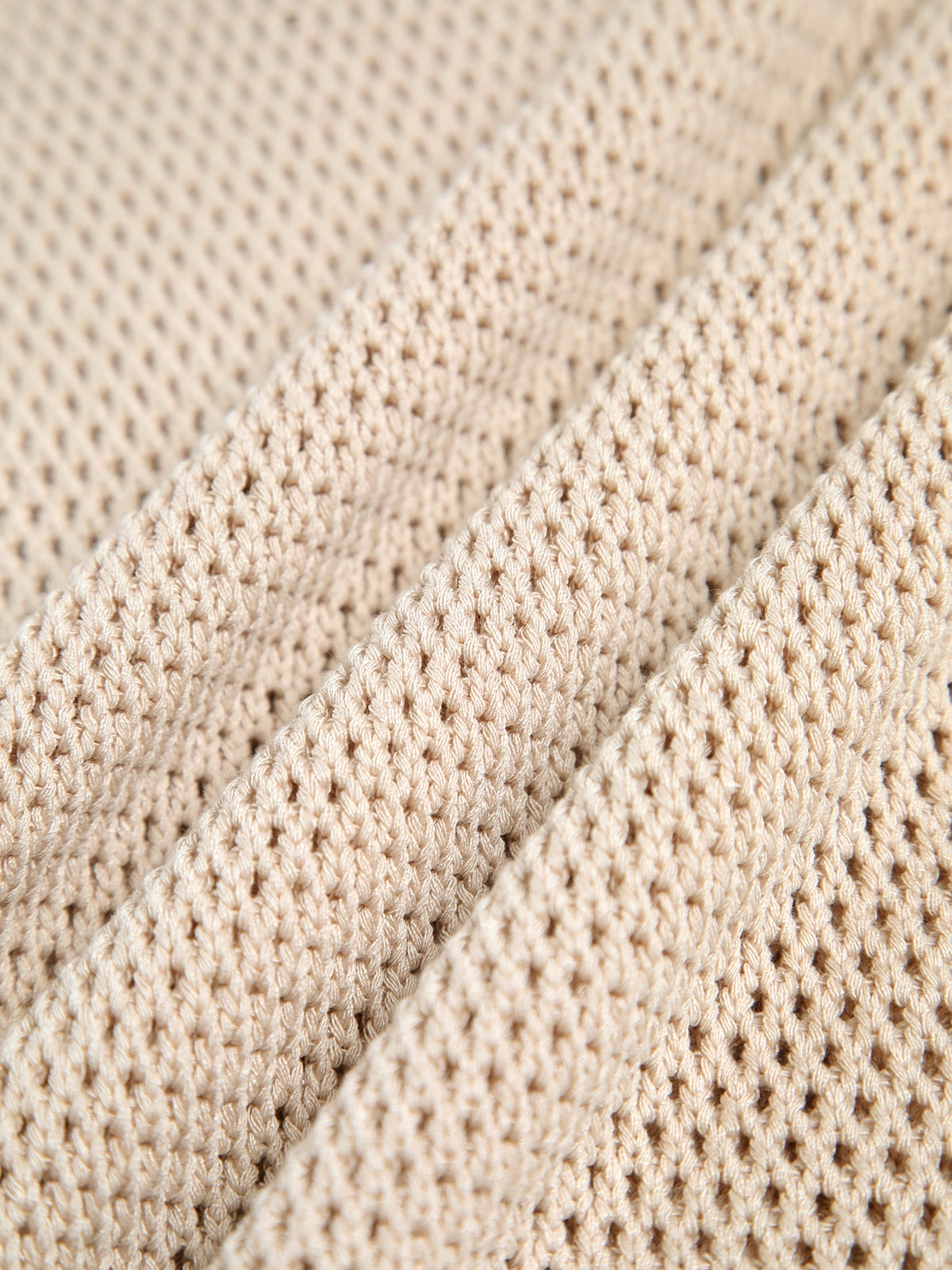 Close-up of cream open-knit crochet texture on a sleeveless cotton tank top