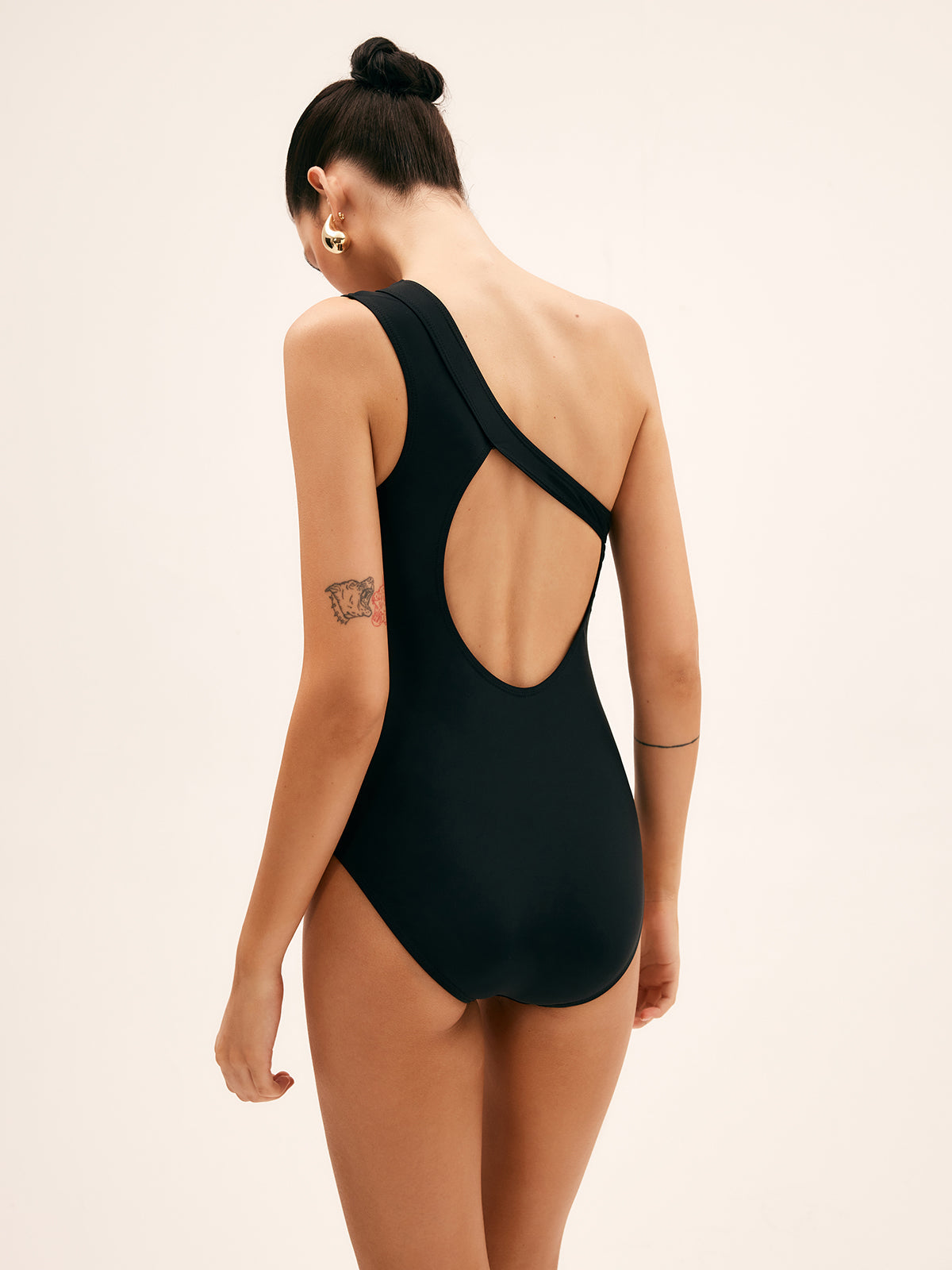Black one-piece swimsuit with open back and diagonal strap detail