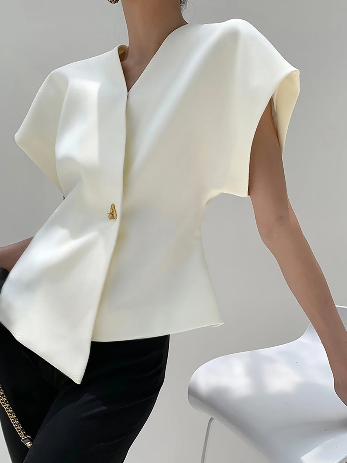 White crepe blouse with V-neck and cap sleeves, asymmetric gold button at center