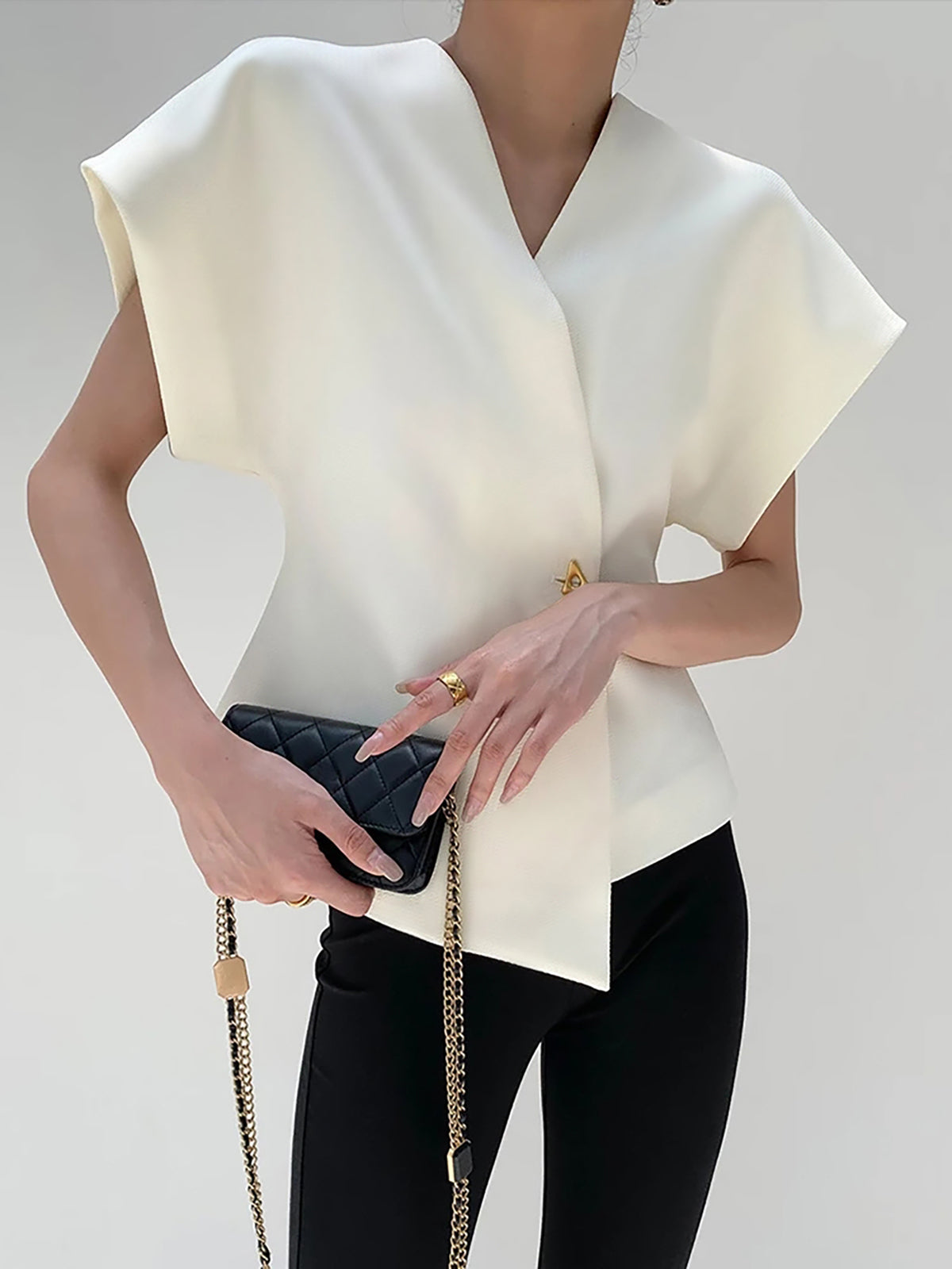 White crepe V-neck blouse with cap sleeves and asymmetric gold button detail