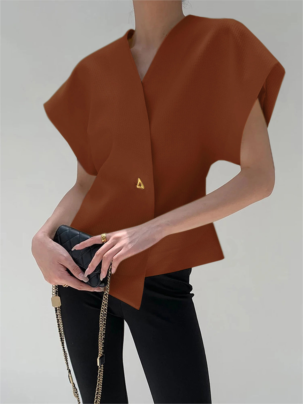 Rust brown crepe blouse with V-neck, cap sleeves, and an asymmetric gold button detail