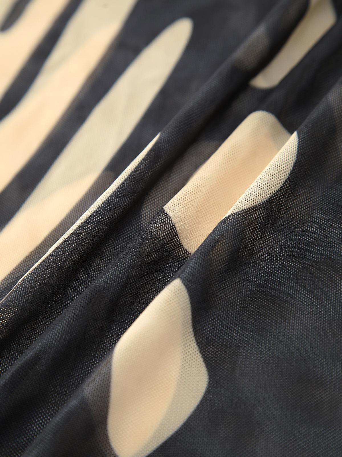 Chiffon fabric close-up with dark base and cream leaf shapes