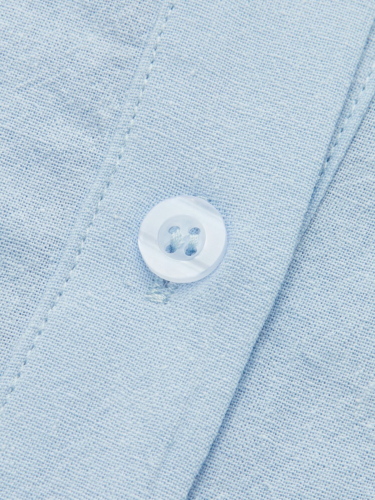 Light blue linen shirt button with visible stitching