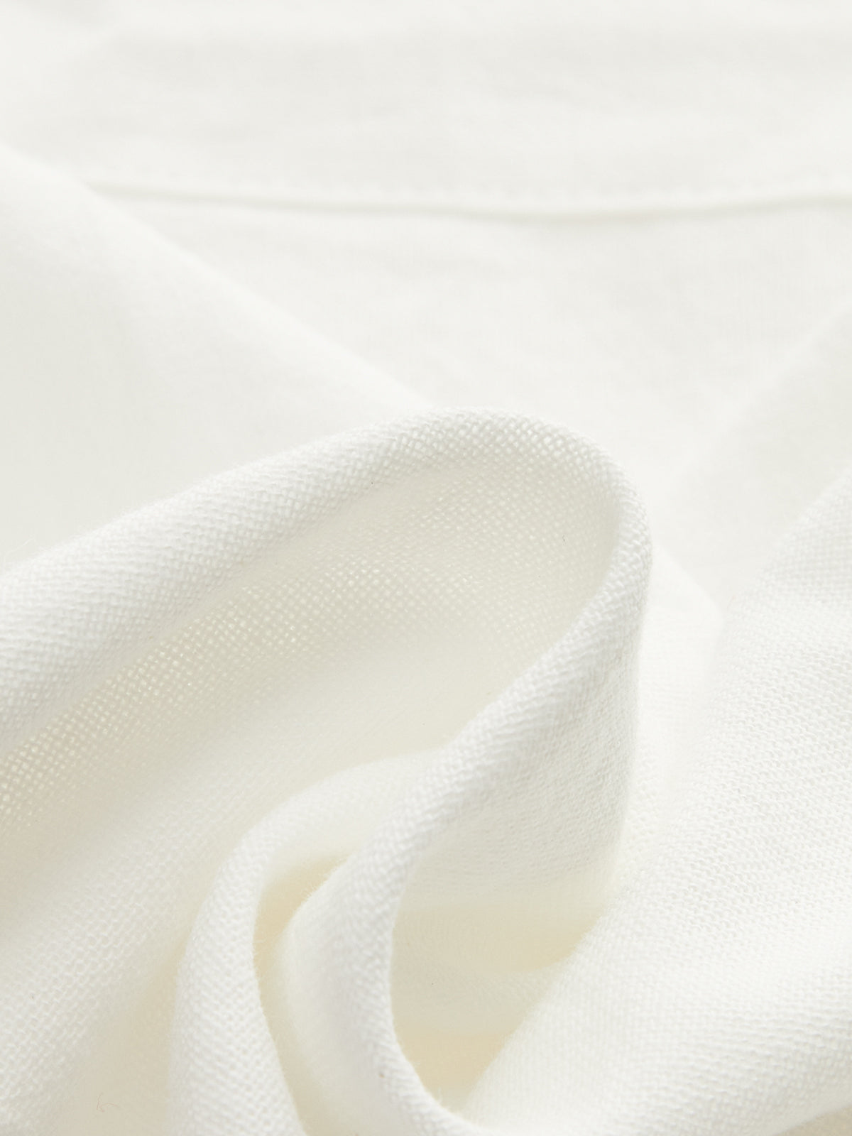 White linen close-up showing woven texture and soft drape