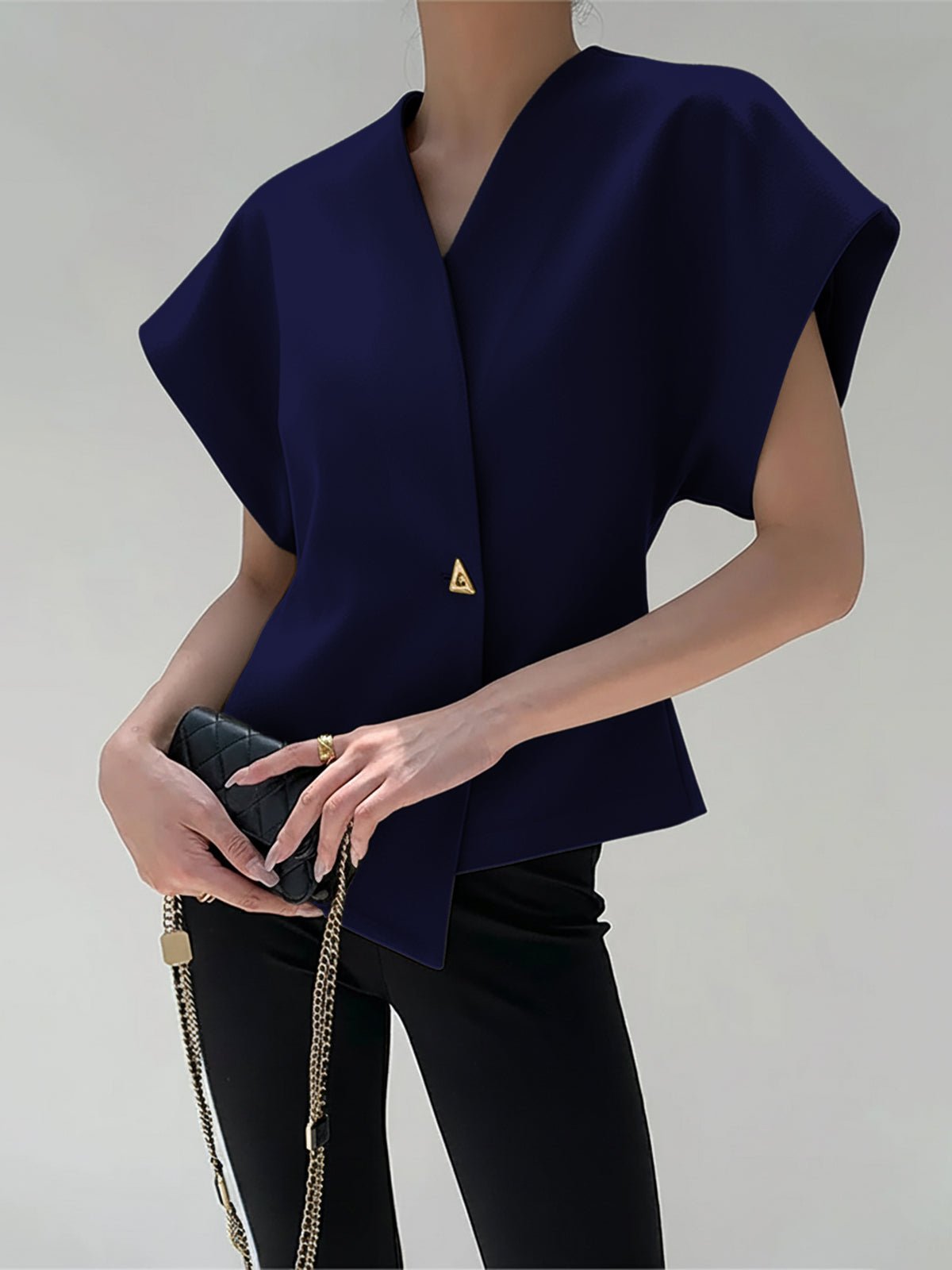 Navy crepe blouse with V-neck, cap sleeves, and an asymmetric gold button detail