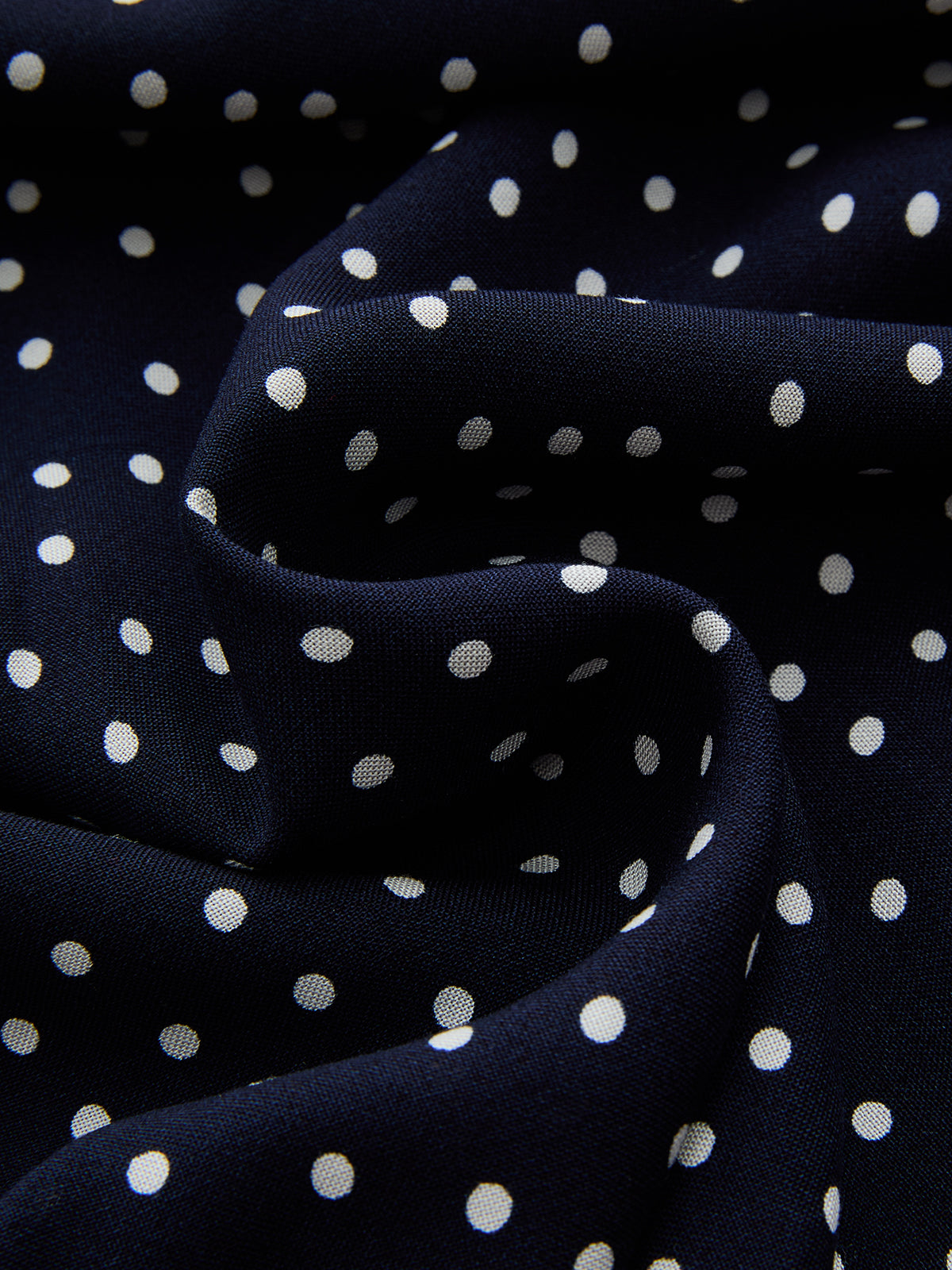 Navy satin fabric with scattered white polka dots