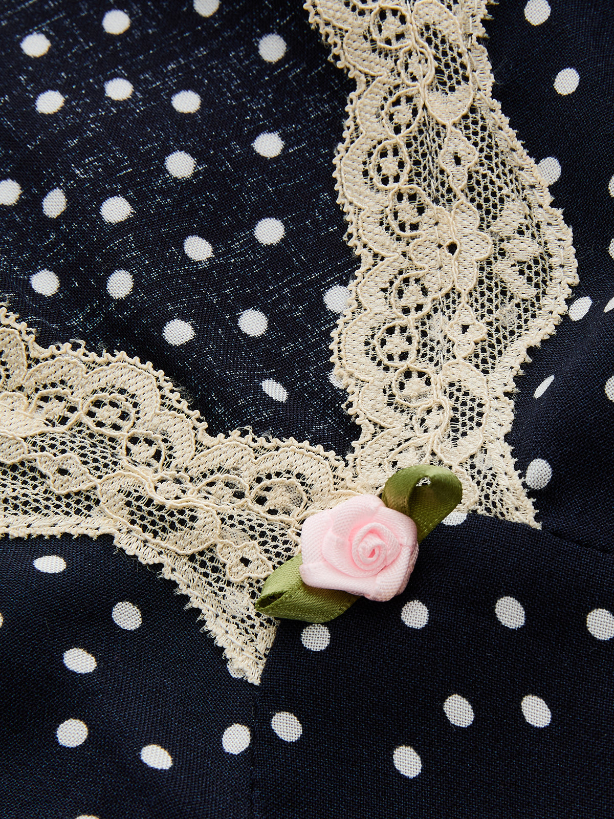 Cream lace V trim on navy polka-dot satin with rose applique detail