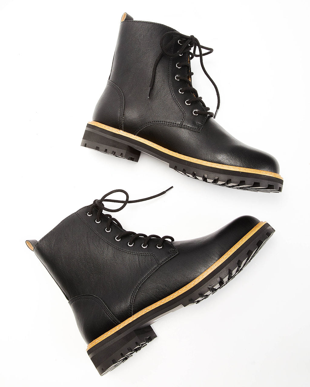 Pair of black faux leather lace-up boots with yellow welt and chunky tread