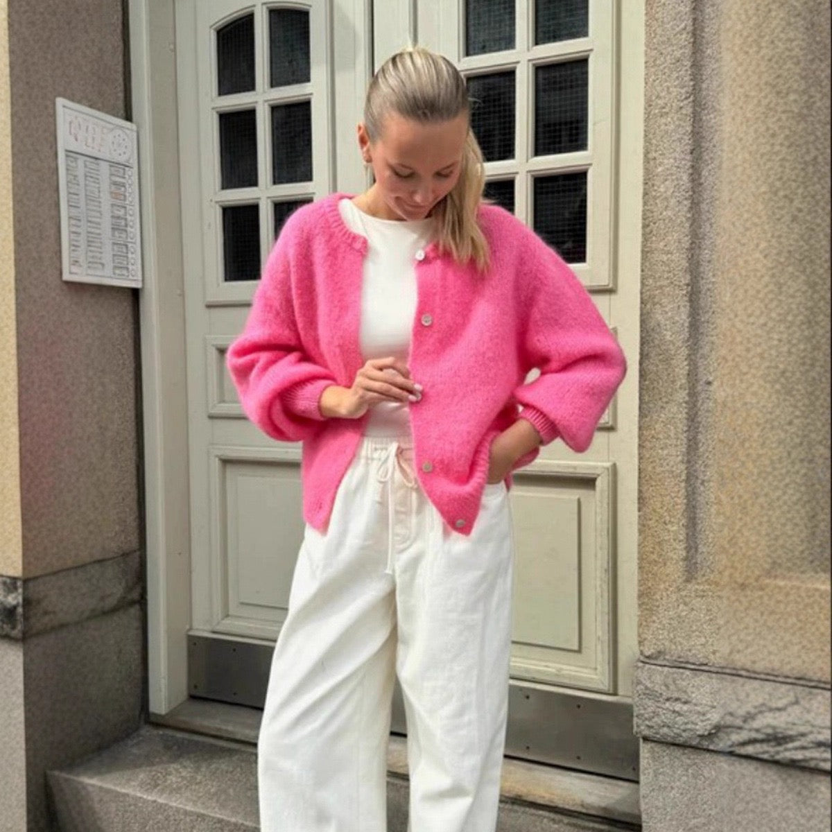 Pink cropped button-front cardigan sweater with round neckline and long sleeves