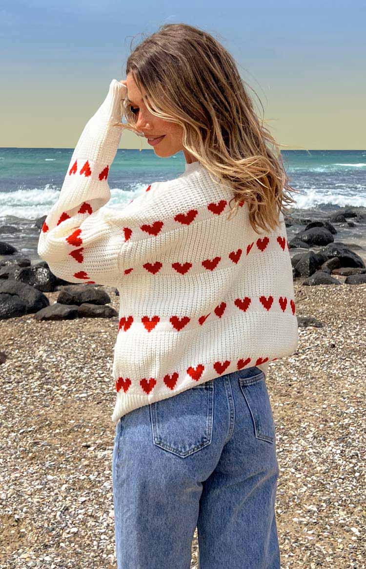 White knit jumper with red heart stripe pattern, crew neck and long sleeves