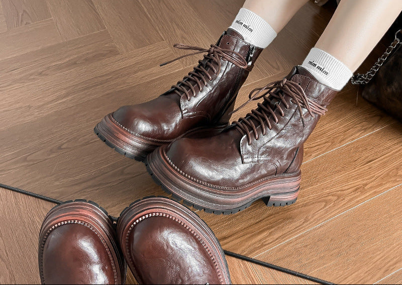 Brown lace-up ankle combat boots with chunky lug sole and stitched panels