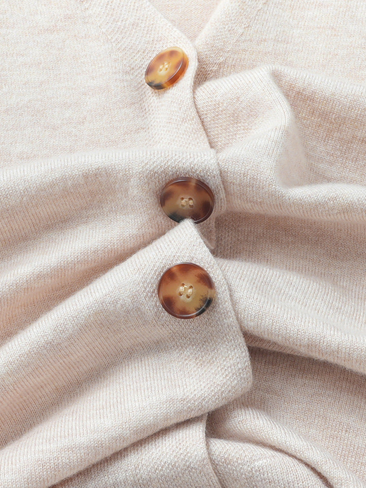 Women’s knit cardigan close-up showing wood-tone buttons on the button placket.