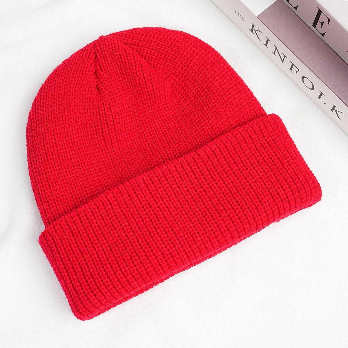 Red thick ribbed knit beanie hat with folded cuff.