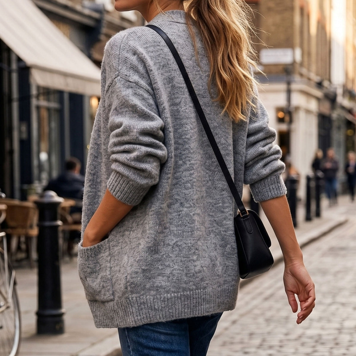 Gray loose knit cardigan with long sleeves, ribbed hem, and side pockets