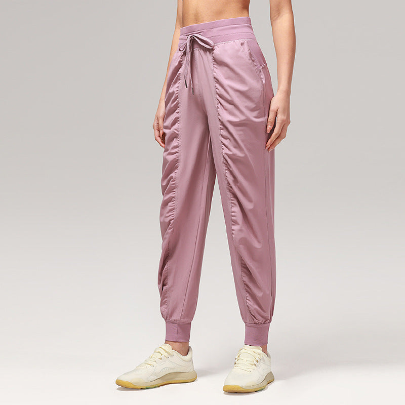 Women’s loose mauve pink jogger pants with drawstring waist and cuffed ankles, side pockets.