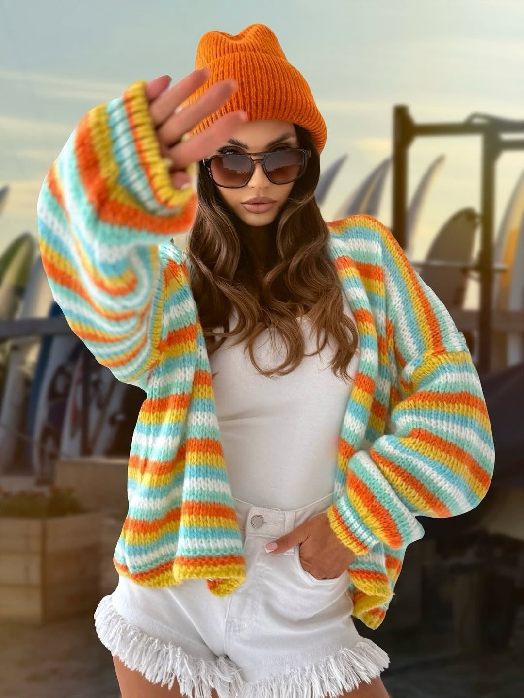 Rainbow striped knit sweater with round neck and long loose sleeves, bright colors