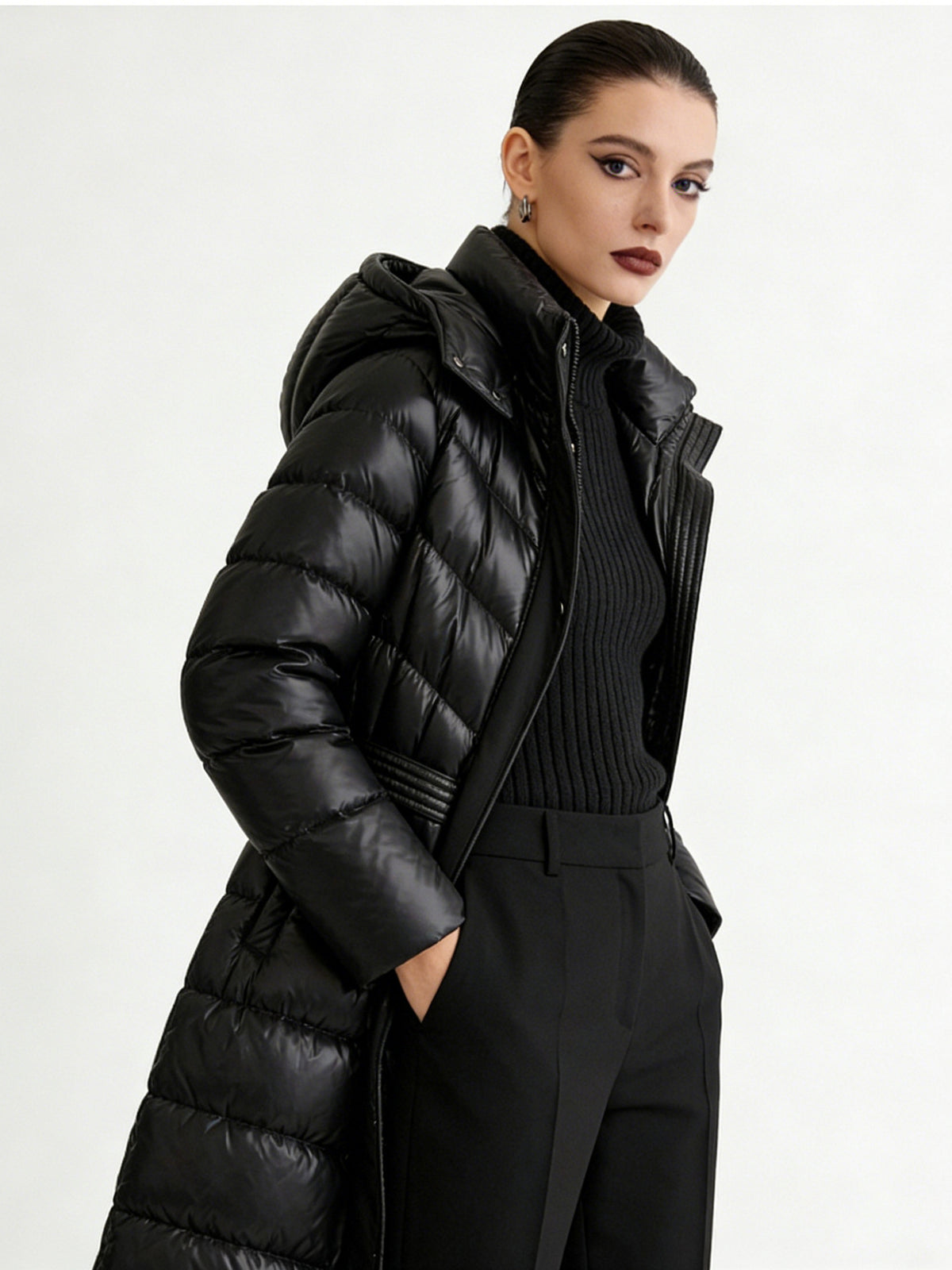 Women's black hooded long puffer jacket with ribbed inner panel and high collar