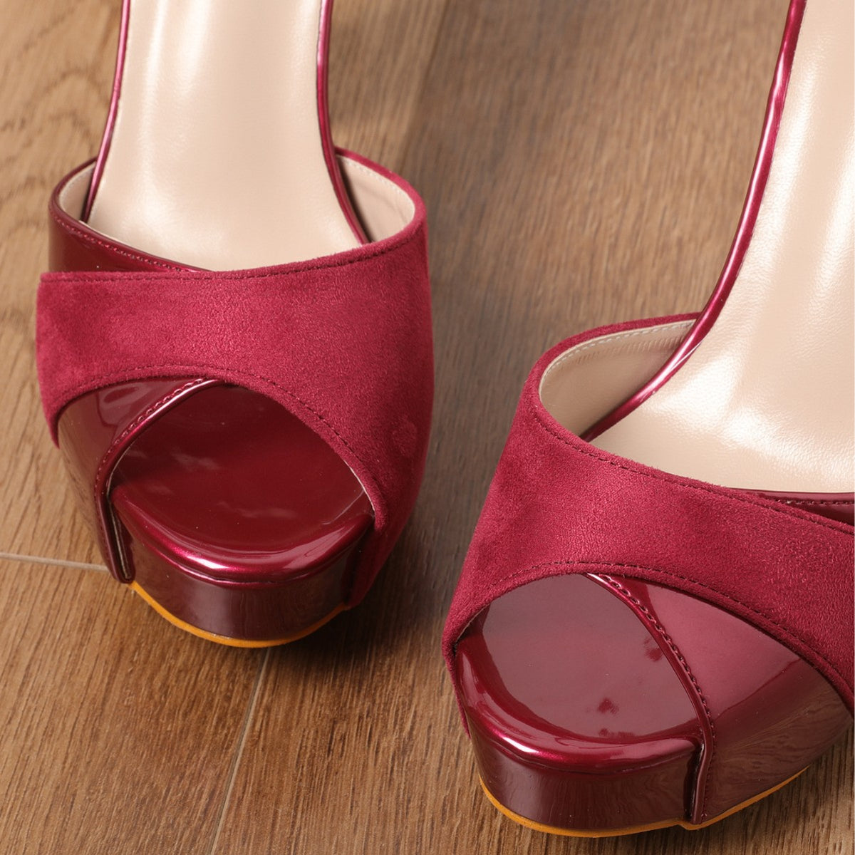 Close-up burgundy peep-toe platform heels with glossy slingback and buckle strap