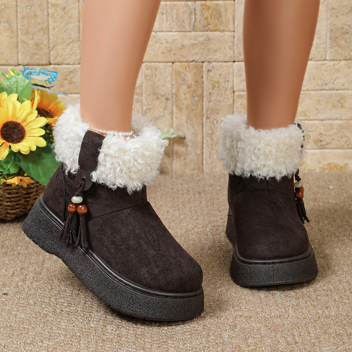 Black suede ankle boots with white faux-fur cuffs and tassel charm decoration