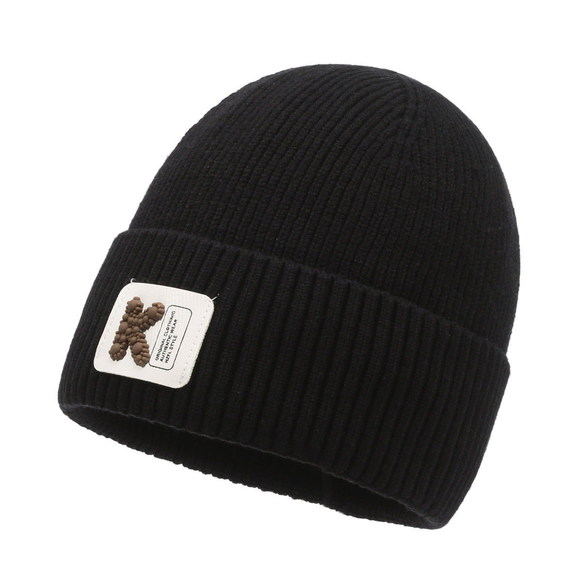 Black rib-knit beanie hat with pom-pom style patch on cuff