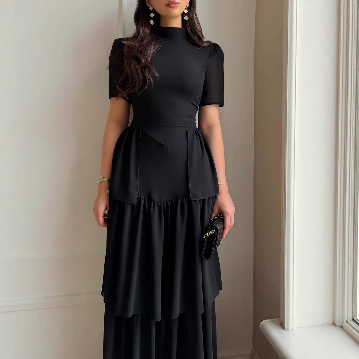 Black chiffon tiered maxi dress with short sleeves and waist tie detailing.
