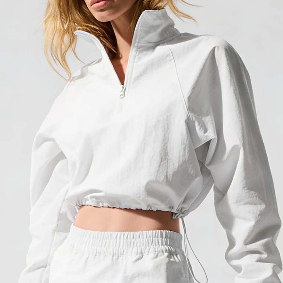 White cropped quarter-zip jacket with drawstring hem and elastic cuffs