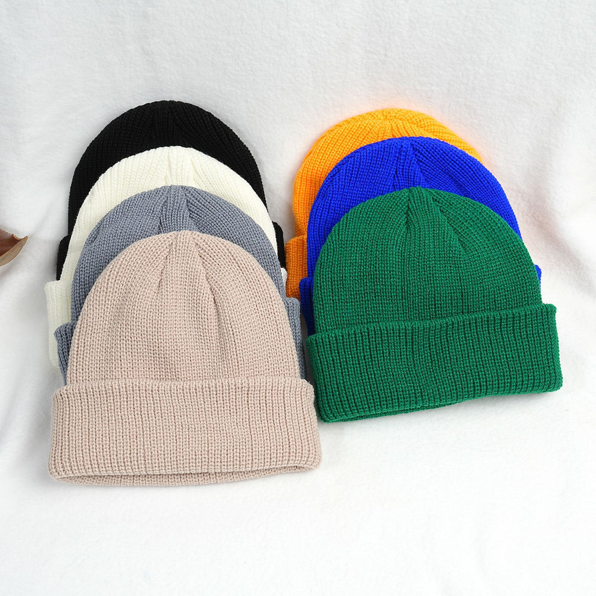 Thick knitted beanie hats in multiple colors, with ribbed cuff and folded brim
