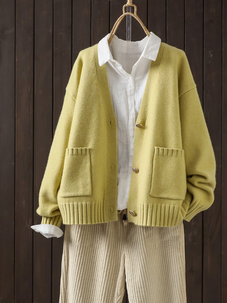 Yellow wool cardigan on hanger with V-neck button front and patch pockets