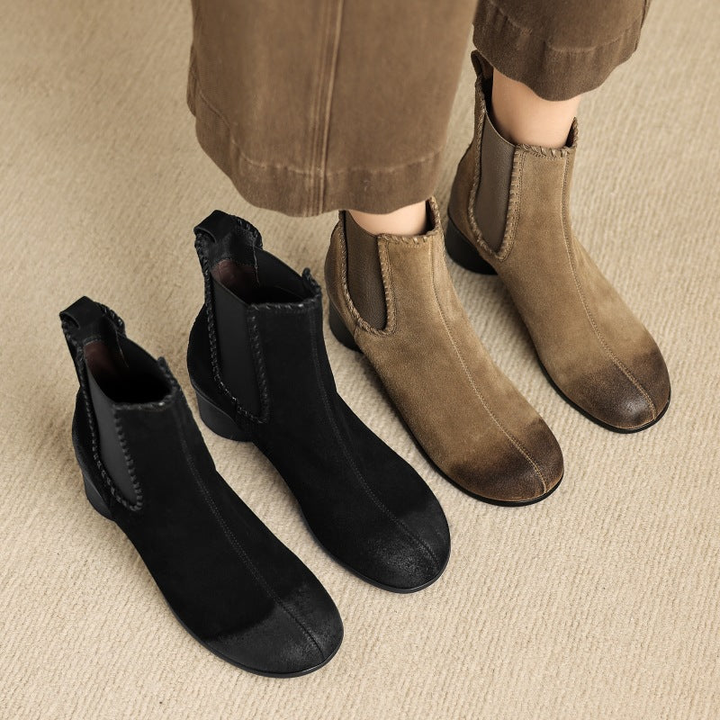 Pair of black suede Chelsea ankle boots with round toe and chunky low heel