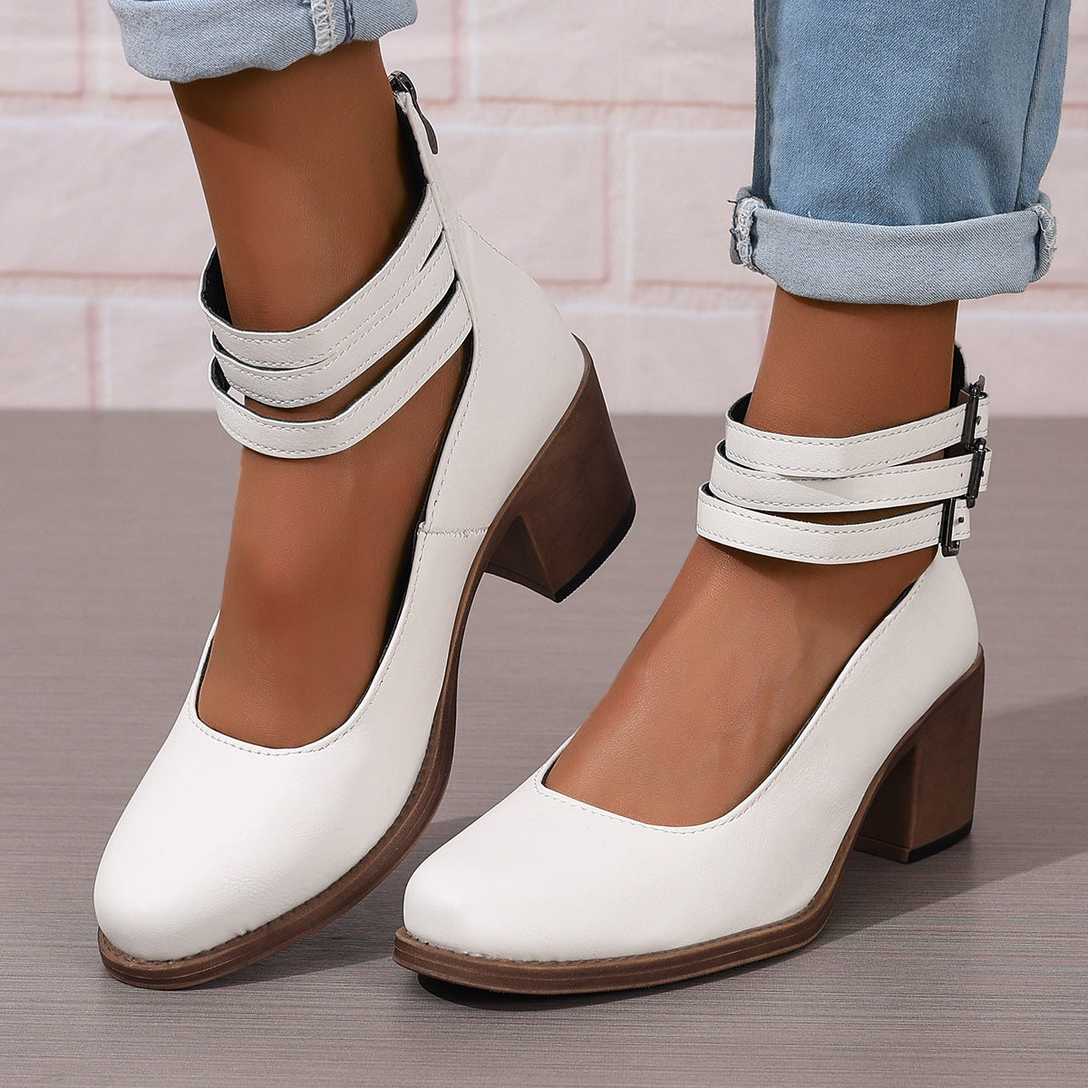 White ankle boots with thick heel and double strap buckle detail