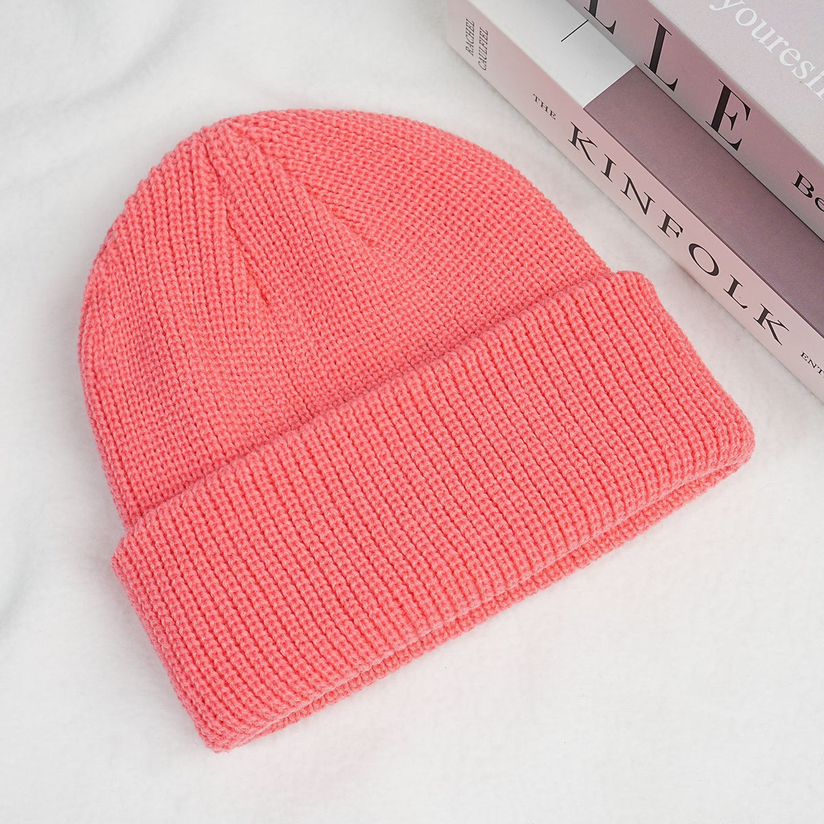 Thick knitted beanie hat in coral pink with folded brim and ribbed cuff