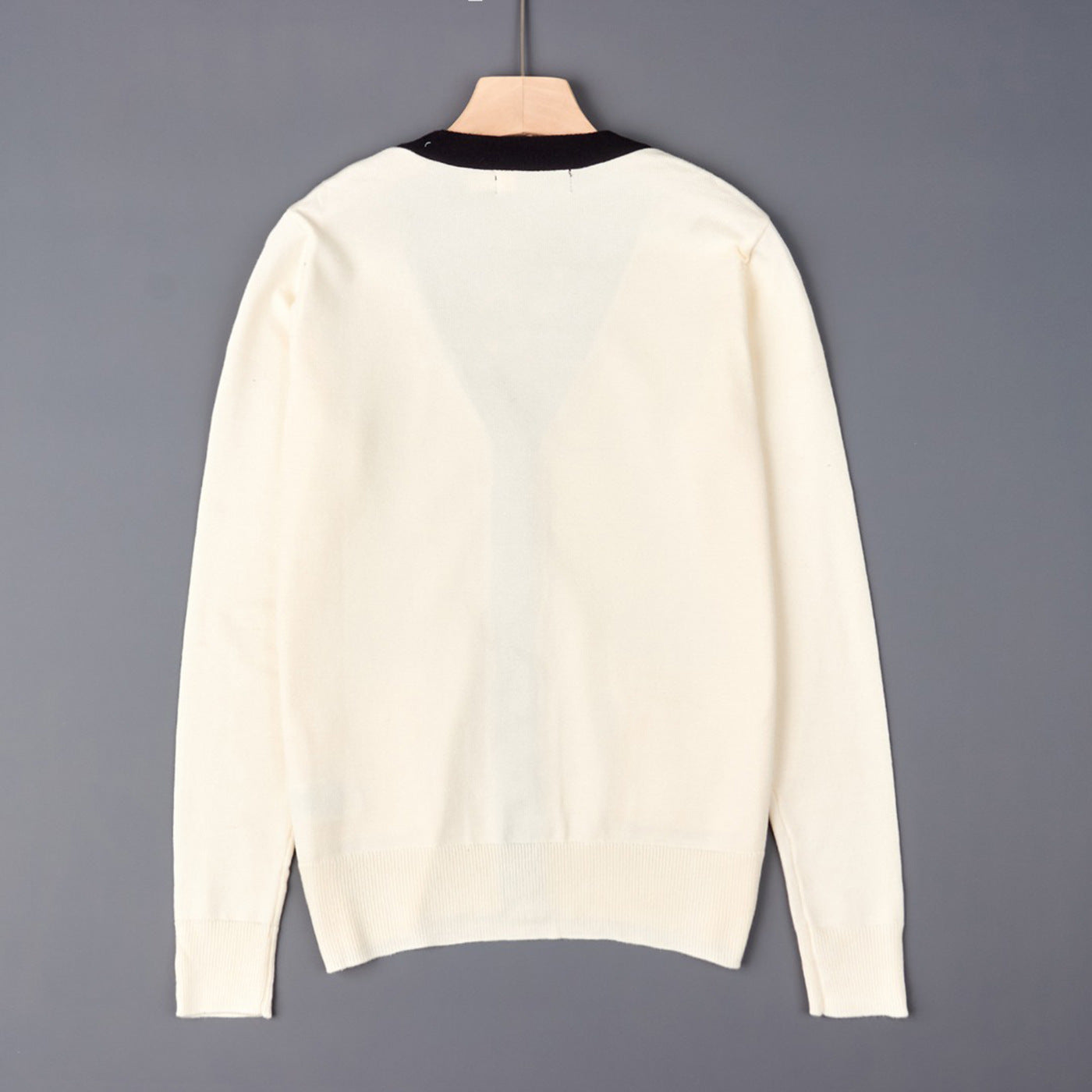Off-white V-neck knit cardigan back view on hanger