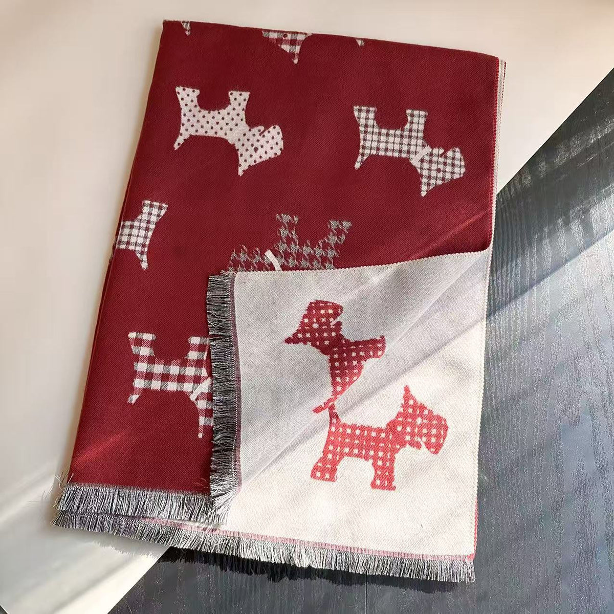 Red scarf with dog motifs, fringed ends, and a contrasting reverse side
